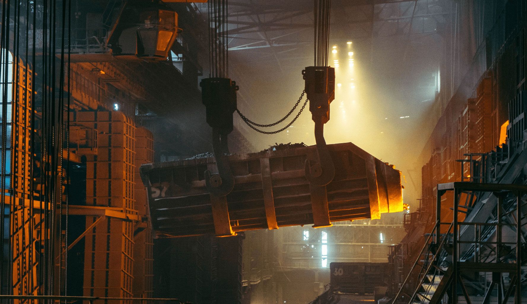 Foundry hall with an overhead crane lifting metal scrap